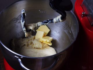 椰蓉花色面包卷,加入黄油，厨师机休息5分钟。