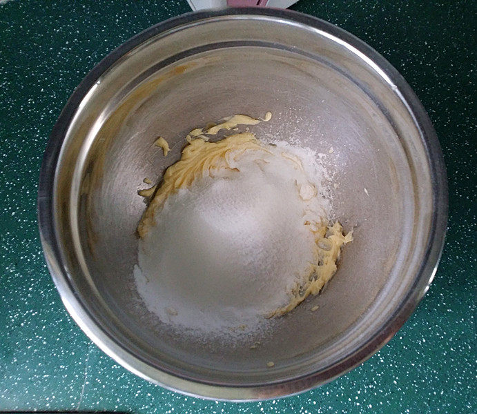 百香果磅蛋糕,接着筛入糖粉和细砂糖，再将黄油打至变白蓬松