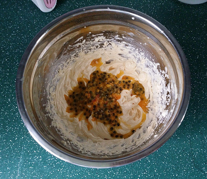 百香果磅蛋糕,接着将百香果汁倒入黄油蛋液中用刮刀拌匀