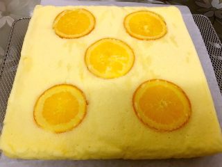 橙香蛋糕卷,底下铺油纸把蛋糕倒扣在烤网上趁热撕下油纸