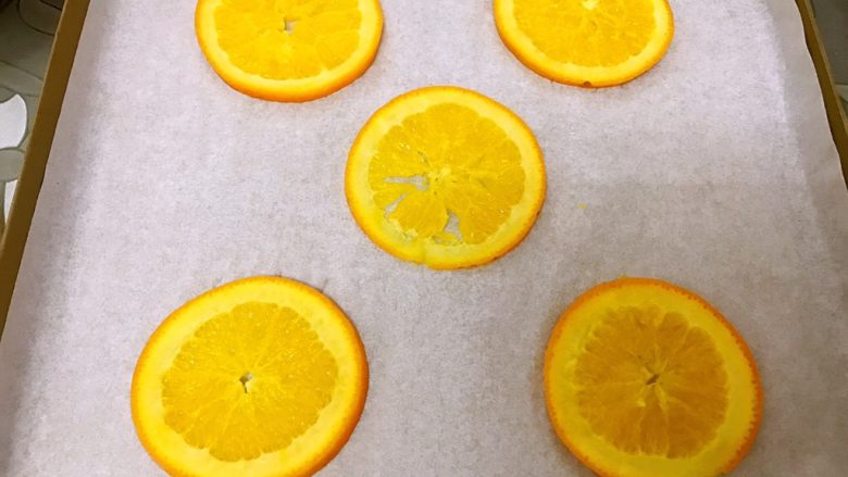 橙香蛋糕卷,烤盘垫油纸摆上橙子片