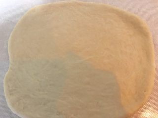 葱香肉松吐司面包,发好的面团用擀面杖擀成薄片。这个对擀的形状没要求。