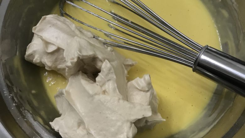 红糖戚风蛋糕卷（后蛋法）,取三分之一蛋白放入蛋黄糊中，用手动打蛋器快速Z字形搅拌均匀