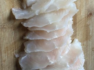 健身餐之西兰花龙利鱼片,龙利鱼解冻，沥干水，横着45度角切成半厘米厚的薄片。