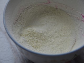火龙果酸奶溶豆,过筛入奶粉和淀粉，搅拌均匀。