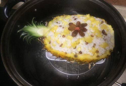 版纳香甜糯萝饭,蒸锅烧水，菠萝饭底部放个小盘，放入蒸锅
