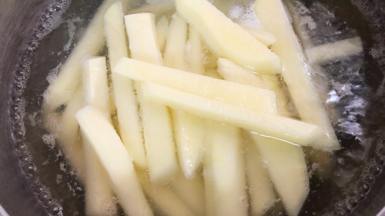 简单易学之炸薯条,水开后放入土豆煮至八分熟