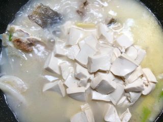 鱼头豆腐汤,放入豆腐，用锅铲轻轻的推动一下