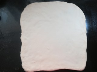 软软豆沙面包卷（70%中种法）,用擀面杖擀成一个正方形的薄片，感慨的尺寸大约长宽30厘米左右。松弛到位的面团才容易擀开，天气比较冷的时候，可能会需要延长松弛的时间。模具使用28×28烤盘，也可以使用烤箱自带的烤盘来做。