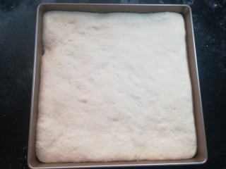 软软豆沙面包卷（70%中种法）,擀开后的面团放入烤盘里，把边缘部分整理好，把烤盘至于温暖的湿润的地方进行二发。温度大约35到38度，湿度在80%左右，发酵至1.5到2倍大。发的太大的话，面包的组织容易粗糙，不利于面包的卷起。