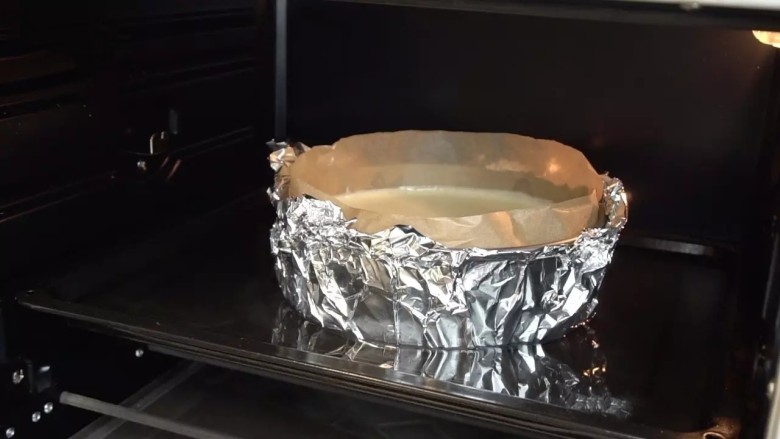 经典重芝士蛋糕,放入预热好155度的烤箱，中下层，在烤盘里倒入开水，水浴烤60分钟。（表面如果提前上色可加盖锡纸）