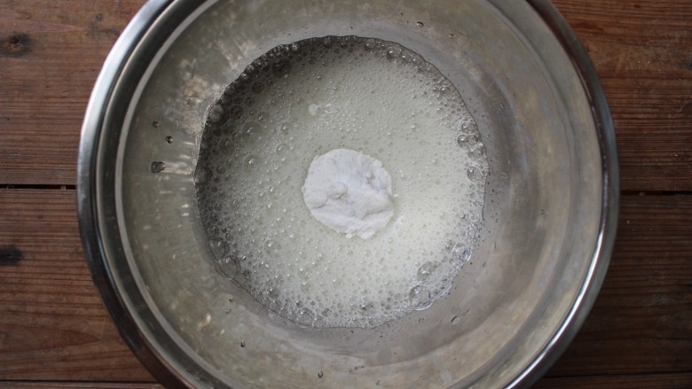 百香果戚风,用电动打蛋器打至粗泡状，加入1/3的糖粉，继续用电动打蛋器打发