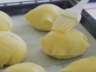 Q弹港式菠萝包,港式菠萝包就是把酥皮盖在发酵好的面团上。两种菠萝包都轻轻刷上蛋液。

讲究的可以只刷蛋黄。成本又上升了。摊手。
