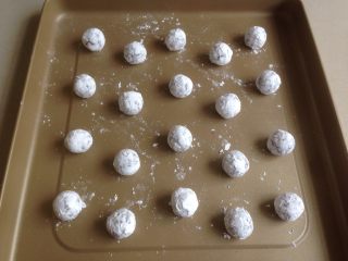 香草巧克力雪球,放在糖粉（配方外）里滚几圈，粘上厚厚的糖霜，放在不粘烤盘上，每个球之间预留足够的位置