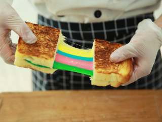彩虹吐司(完美超长拉丝),出炉后，用面包刀将吐司两面各横切一刀，切勿切断。