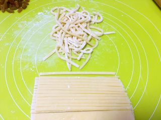 沙琪玛,用刀切成宽度0.2厘米的条，切一点撒一点玉米淀粉，防止面条粘在一起