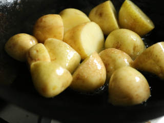 肉末酱香小土豆,小土豆表面水分擦干，放入油锅中火煎至表面金黄，捞出控油待用。