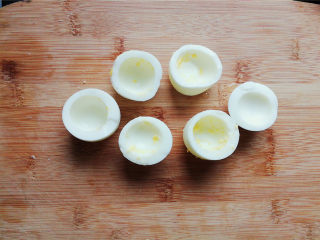 鸡蛋香肠沙拉杯,把鸡蛋对半切开，蛋黄挖掉跟主料一起，蛋白杯底部切平，能站立即可