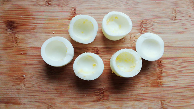 鸡蛋香肠沙拉杯,把鸡蛋对半切开，蛋黄挖掉跟主料一起，蛋白杯底部切平，能站立即可