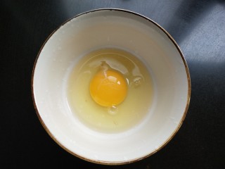 抱蛋煎饺,鸡蛋打入碗中。