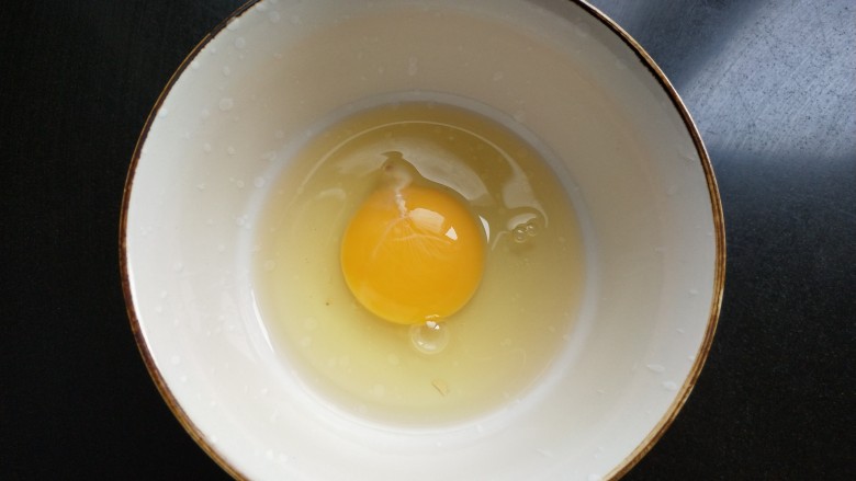 抱蛋煎饺,鸡蛋打入碗中。