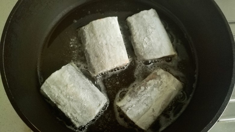 辣烧带鱼,锅中放油烧热，放入粘好干淀粉的带鱼煎制，(我锅小分两次煎带鱼)。
