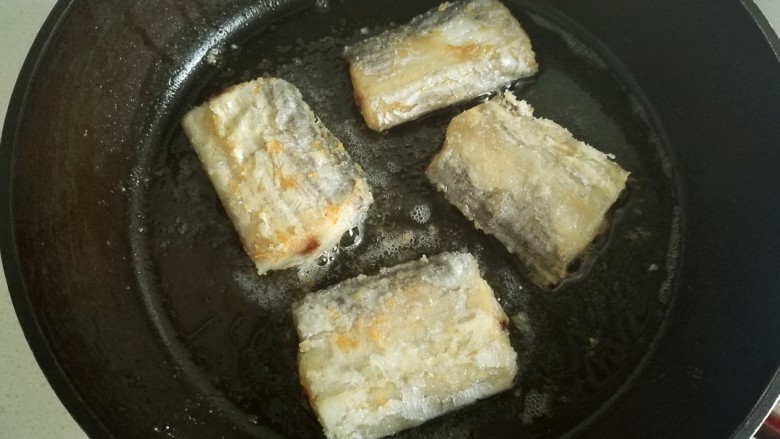 辣烧带鱼,煎至带鱼金黄后盛出备用。