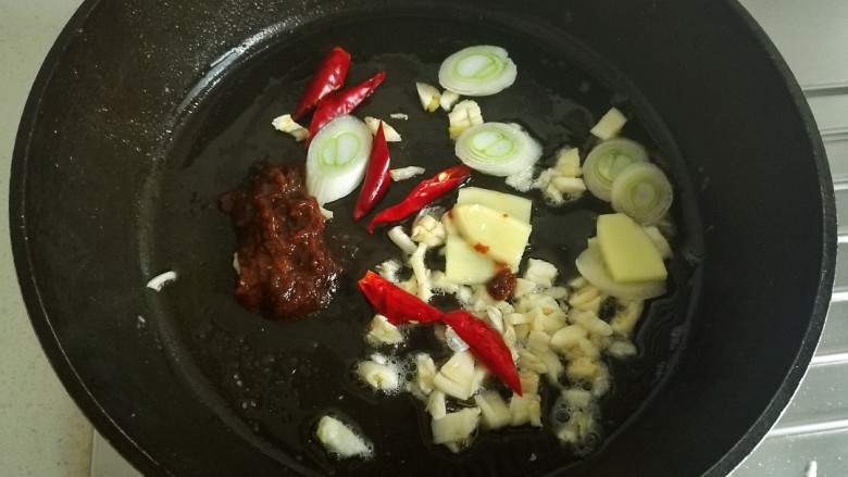 辣烧带鱼,锅中放少许底油，放入葱姜蒜，干辣椒，豆瓣酱翻炒。