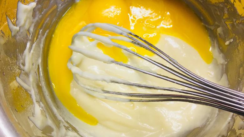 可可波纹戚风蛋糕,加入蛋黄Z字搅拌均匀后，加入香草精华搅拌均匀。