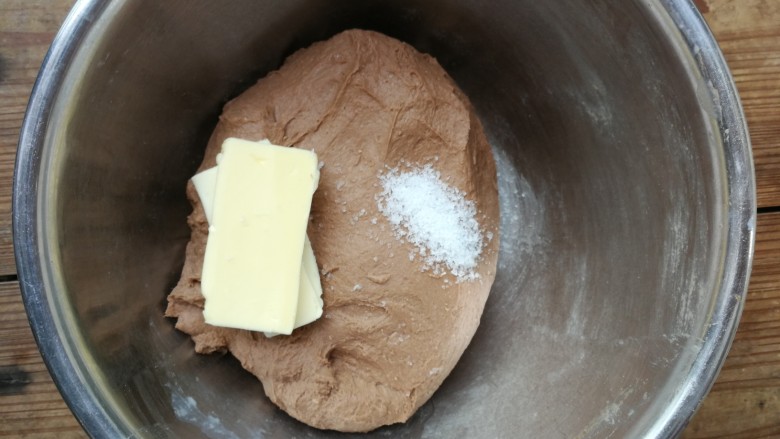 蔓越莓巧克力软欧,和成光滑的面团后加入软化的黄油和盐，继续揉面