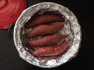 砂锅烤红薯,把清洗干净的红薯沥干水分放到锡纸上，盖上砂锅盖。