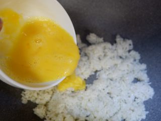 香菜火腿炒饭,淋上蛋液后，迅速翻炒，让蛋液均匀包裹米饭。