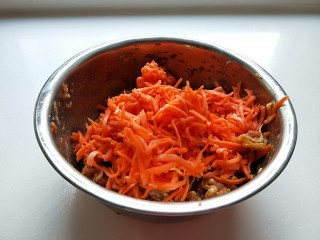猪肉胡萝卜花样蒸饺,在用手剂出水分，胡萝卜丝会变软了，在放入盆中。