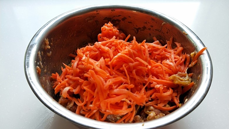 猪肉胡萝卜花样蒸饺,在用手剂出水分，胡萝卜丝会变软了，在放入盆中。