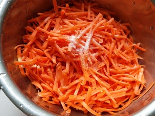 猪肉胡萝卜花样蒸饺,用擦丝器擦丝，加入适量盐抓均匀。