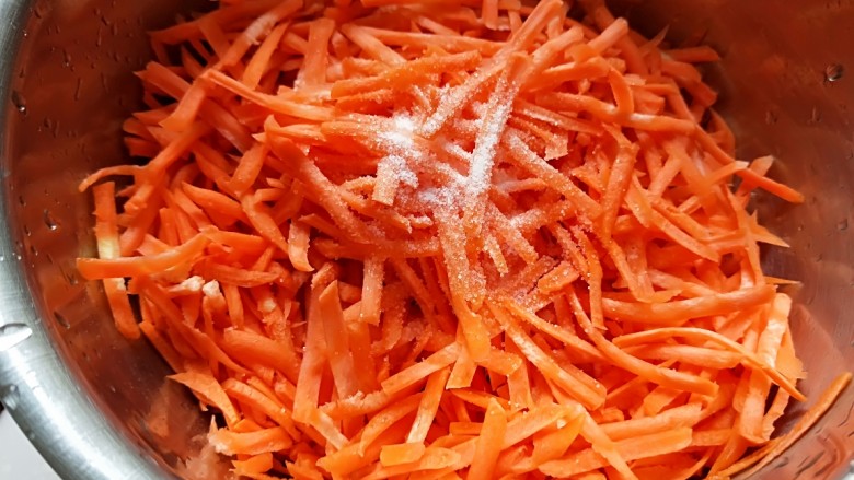 猪肉胡萝卜花样蒸饺,用擦丝器擦丝，加入适量盐抓均匀。