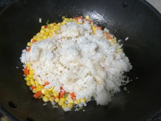 金灿灿的玉米炒饭,倒下剩饭翻炒后，马上加入刚刚准备好的调料，再继续翻炒几下就可以出锅了。
