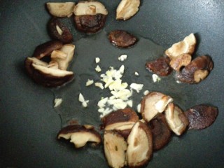香菇菜心,把香菇扒拉到四周，中间放食用油，放蒜末爆香。
