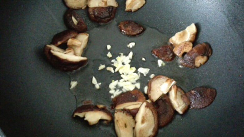 香菇菜心,把香菇扒拉到四周，中间放食用油，放蒜末爆香。
