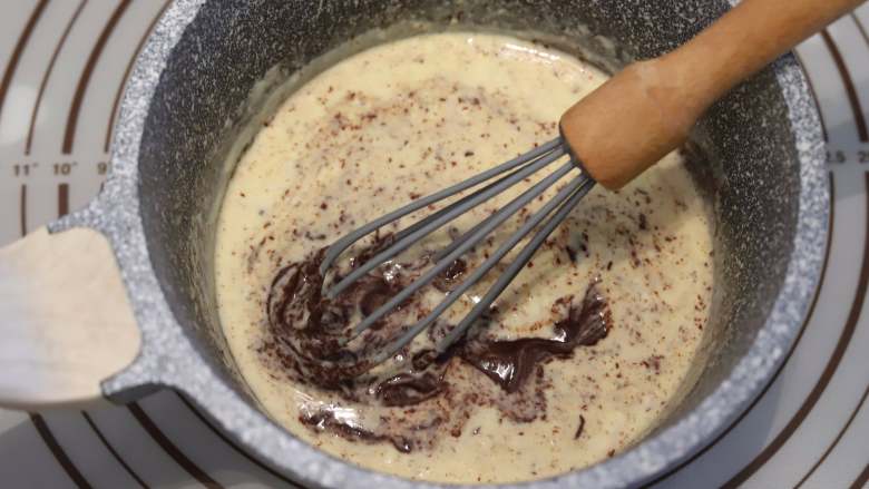巧克力甘纳许杯子蛋糕,晃动淡奶油，使淡奶油全部盖住巧克力币，静置5分钟，画圆圈方式搅拌