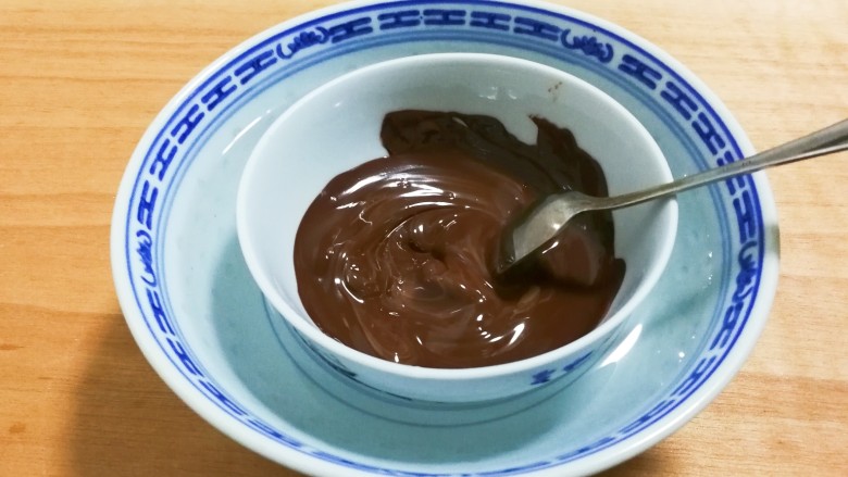 巧克力鱼棒棒糖,用勺子搅拌融化的巧克力