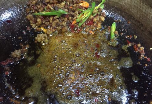 蚂蚁肉沫焗香辣花菜,把肉沫推至锅的一边