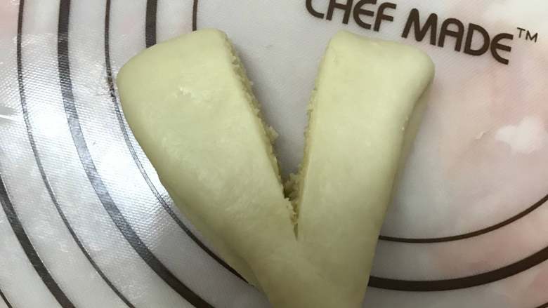 奶香椰蓉面包,用锋利的刀片从中间切开，注意底部不要切断。
