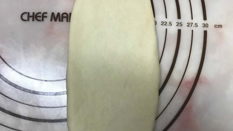 奶香椰蓉面包,将面团擀成椭圆形。
