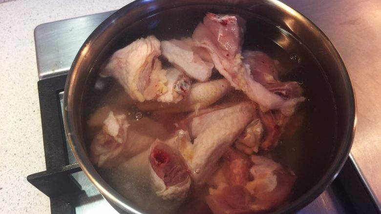 虫草花汽锅鸡,冷水下鸡块，放入三片姜和适量料酒，煮沸。