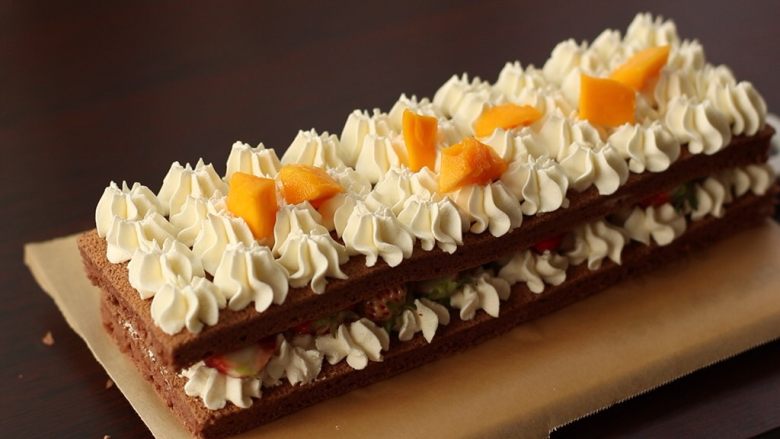 草莓裸蛋糕,再叠一层蛋糕片，挤奶油霜，放芒果块