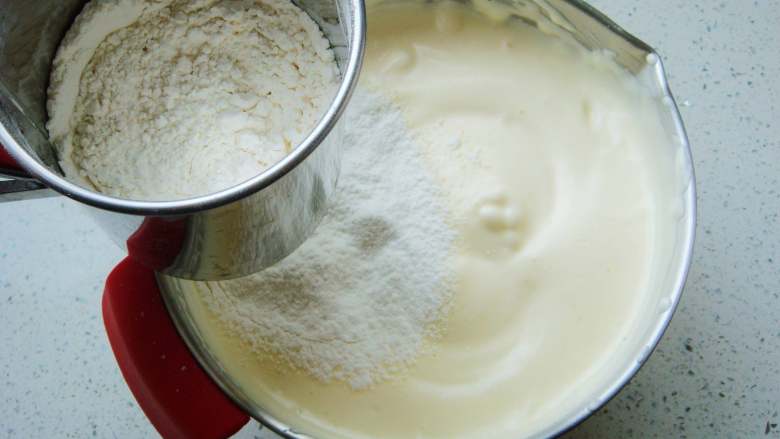 心形海绵蛋糕,先筛入一半的面粉，翻拌均匀后再次筛入余下的面粉。