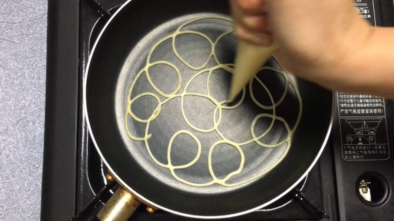 五彩网格蛋卷,热锅，不用刷油，将面糊挤出花纹图案，网格图案都可以