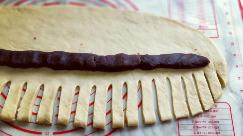 浪漫花环杏仁豆沙面包,用锋利的水果刀切成1.3cm的条状。