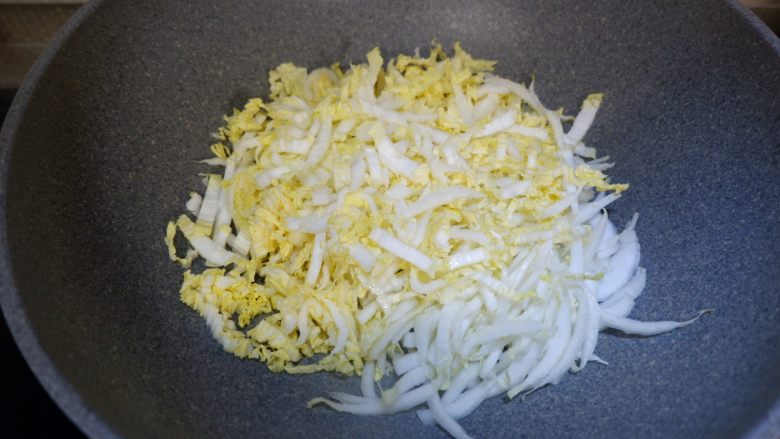鲜贝白菜滑蛋（无油）,将白菜拌匀，均匀的铺在锅底。